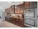 Modern kitchen with dark brown cabinets, granite countertops, and stainless steel appliances at 5410 Whisper Ct, Cumming, GA 30028