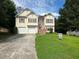 Two-story house with a two-car garage and landscaped yard at 3393 Madison Farm Way, Snellville, GA 30039
