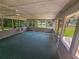 Spacious sunroom with large windows, ceiling fan, and green carpet at 8347 Hilltop Rd, Jonesboro, GA 30236