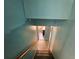 Indoor stairs leading to lower level with teal walls at 8347 Hilltop Rd, Jonesboro, GA 30236