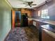 A galley kitchen with wood cabinets, black appliances, and tiled floor at 8347 Hilltop Rd, Jonesboro, GA 30236
