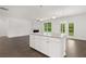 Open concept kitchen with large island, white cabinets and hardwood floors at 1698 Lacebark Elm Way, Lawrenceville, GA 30045