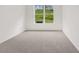 Spacious bedroom with neutral carpeting and large window at 1698 Lacebark Elm Way, Lawrenceville, GA 30045