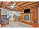 Living room with hardwood floors, stone fireplace, and exposed wooden beams at 2841 Upper Sweetwater Se Trl, White, GA 30184