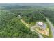 Aerial view showing home, wooded area, and roadway at 2841 Upper Sweetwater Se Trl, White, GA 30184