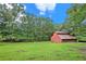 Red barn with metal roof sits on a grassy lot, surrounded by trees at 2841 Upper Sweetwater Se Trl, White, GA 30184