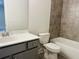 Bathroom with gray vanity, toilet, and bathtub at 2190 W Village Ln, Smyrna, GA 30080