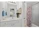 Bathroom with white vanity, bathtub, and floral shower curtain at 5725 Lake Oak Lndg, Cumming, GA 30040