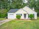 Yellow house with attached garage and large yard at 15 Marissa Cv, Riverdale, GA 30274