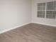 Empty bedroom with wood-look vinyl flooring and a window with blinds at 15 Marissa Cv, Riverdale, GA 30274