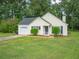 Yellow house with attached garage and large yard at 15 Marissa Cv, Riverdale, GA 30274