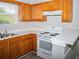 Modern kitchen with wood cabinets, white appliances, and corner sink at 15 Marissa Cv, Riverdale, GA 30274