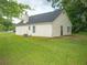 Rear view of a ranch house with a yard and mature trees at 15 Marissa Cv, Riverdale, GA 30274