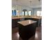 Kitchen island with granite countertop and dark wood cabinets at 190 Thrushwood Dr, Fayetteville, GA 30215
