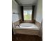 Relaxing bathroom featuring a soaking tub and window views at 190 Thrushwood Dr, Fayetteville, GA 30215