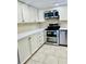 Updated kitchen with white cabinets, stainless steel appliances, and tile floors at 307 Lakemoore Ne Dr # D, Atlanta, GA 30342
