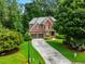 Two-story home with driveway, nestled in a wooded area at 5425 Edinbourgh Ct, Cumming, GA 30040