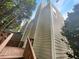 Rear view of two-story townhome, showcasing a deck and mature trees at 5319 Pinnacle Peak Ln, Norcross, GA 30071