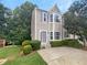 Two-story townhome exterior with gray siding, landscaping and a paved driveway at 5319 Pinnacle Peak Ln, Norcross, GA 30071