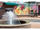 Community fountain with brick base, surrounded by a plaza with colorful mural and seating at 945 Willingham Dr # 3, Hapeville, GA 30354