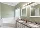 Bathroom with double vanity, granite countertop, and jetted tub at 140 Wisteria Blvd, Covington, GA 30016