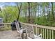 Wooden deck overlooking a wooded backyard, with rocking chairs and grill at 140 Wisteria Blvd, Covington, GA 30016