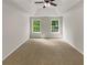 Spacious bedroom with neutral carpeting and ample natural light at 254 Lantana Dr, Locust Grove, GA 30248