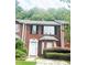Brick townhouse exterior with 2-story elevation, white door, and landscaping at 2794 Norfair Loop, Lithonia, GA 30038