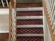 Indoor staircase with dark wood treads and maroon runners at 1080 Meadow Walk Ave, Lawrenceville, GA 30044
