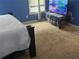 Bright bedroom with neutral carpeting and a large TV at 1080 Meadow Walk Ave, Lawrenceville, GA 30044