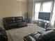 Living room with leather reclining sofas and a large TV at 1080 Meadow Walk Ave, Lawrenceville, GA 30044