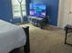 Blue bedroom with a large TV and carpeted floor at 1080 Meadow Walk Ave, Lawrenceville, GA 30044