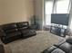 Living room with leather reclining sofas and a large TV at 1080 Meadow Walk Ave, Lawrenceville, GA 30044