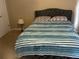 Bedroom with a gray upholstered bed and striped bedding at 1080 Meadow Walk Ave, Lawrenceville, GA 30044