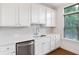 Modern kitchen with white cabinets, stainless steel dishwasher, and hardwood floors at 3701 Allegretto Cir, Atlanta, GA 30339