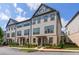 Three-story beige townhouse with gray accents and landscaping at 3701 Allegretto Cir, Atlanta, GA 30339