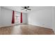 Bright bedroom featuring wood-look flooring and red curtains at 6851 Roswell Rd # B8, Sandy Springs, GA 30328