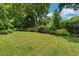 Spacious backyard with a large lawn, mature trees, and wooden fence at 161 Blair Valley Ne Dr, Marietta, GA 30060