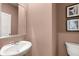 Small powder room with white sink and toilet, and updated mirror at 318 Elgin Dr, Lawrenceville, GA 30045