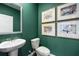 Powder room features a pedestal sink, toilet, and green walls at 1422 Gray Branch Dr, Lawrenceville, GA 30045