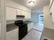 Kitchen with white cabinets, gray countertops, and black appliances at 1472 Pine Log Ne Rd, Conyers, GA 30012