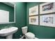 Modern powder room with green walls and stylish framed art at 328 Elgin Dr, Lawrenceville, GA 30045