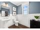 Elegant powder room features white pedestal sink, toilet and wainscoting at 3739 Tielman St, Snellville, GA 30078