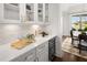 Butler's pantry with white cabinets, quartz countertops, and wine cooler at 3739 Tielman St, Snellville, GA 30078