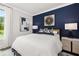 Main bedroom with a king-size bed, navy accent wall, and hardwood floors at 3869 Tielman St, Snellville, GA 30078