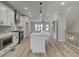 Open concept kitchen with island, white cabinets and hardwood floors at 1996 Deco Dr, Kennesaw, GA 30144