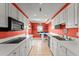 White kitchen cabinets, coral walls, and tile floors at 3435 Kingsboro Ne Rd # 1201, Atlanta, GA 30326
