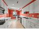 White kitchen cabinets, coral walls, and tile floors at 3435 Kingsboro Ne Rd # 1201, Atlanta, GA 30326