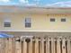 Rear view of house showing yellow siding and brick, with a wooden fence at 608 Summer Pl, Norcross, GA 30071