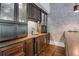 Basement wet bar with dark wood cabinets, granite countertops and brick feature wall at 4317 Oglethorpe Nw Loop, Acworth, GA 30101